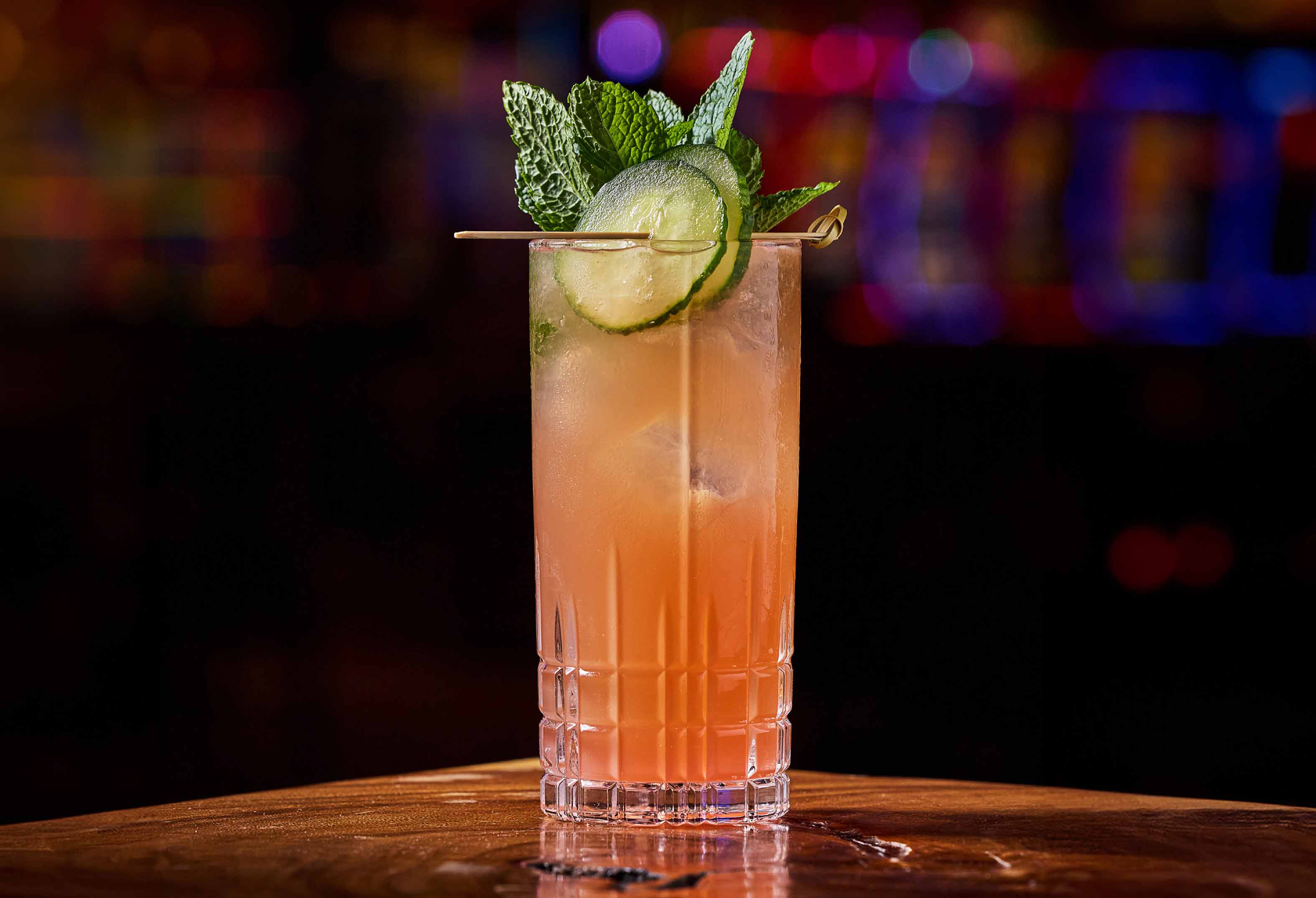 Orange cocktail with cucumber and mint garnish at L Bar at Seminole Hard Rock Hollywood